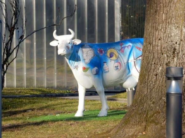 Une étrange vache transgènique au regard de batracien observe les visiteurs .Elle est couverte de logos indechiffrables pour un profane
