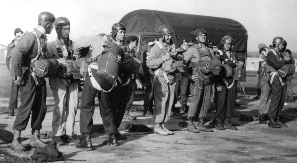  Inspection avant le saut par le lieutenant Roger PHILIPPON .Les 4 sautants à droite portent des casques en metal d' entrainement modèle 1945 Les autres sautants à gauches ont coiffé des casques de cuir d' aviateurs modèle 1934 
