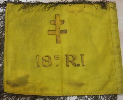 au revers une Croix de Lorraine et la désignation du corps : 18° R.I. Il est de couleur JAUNE sur ses deux faces  